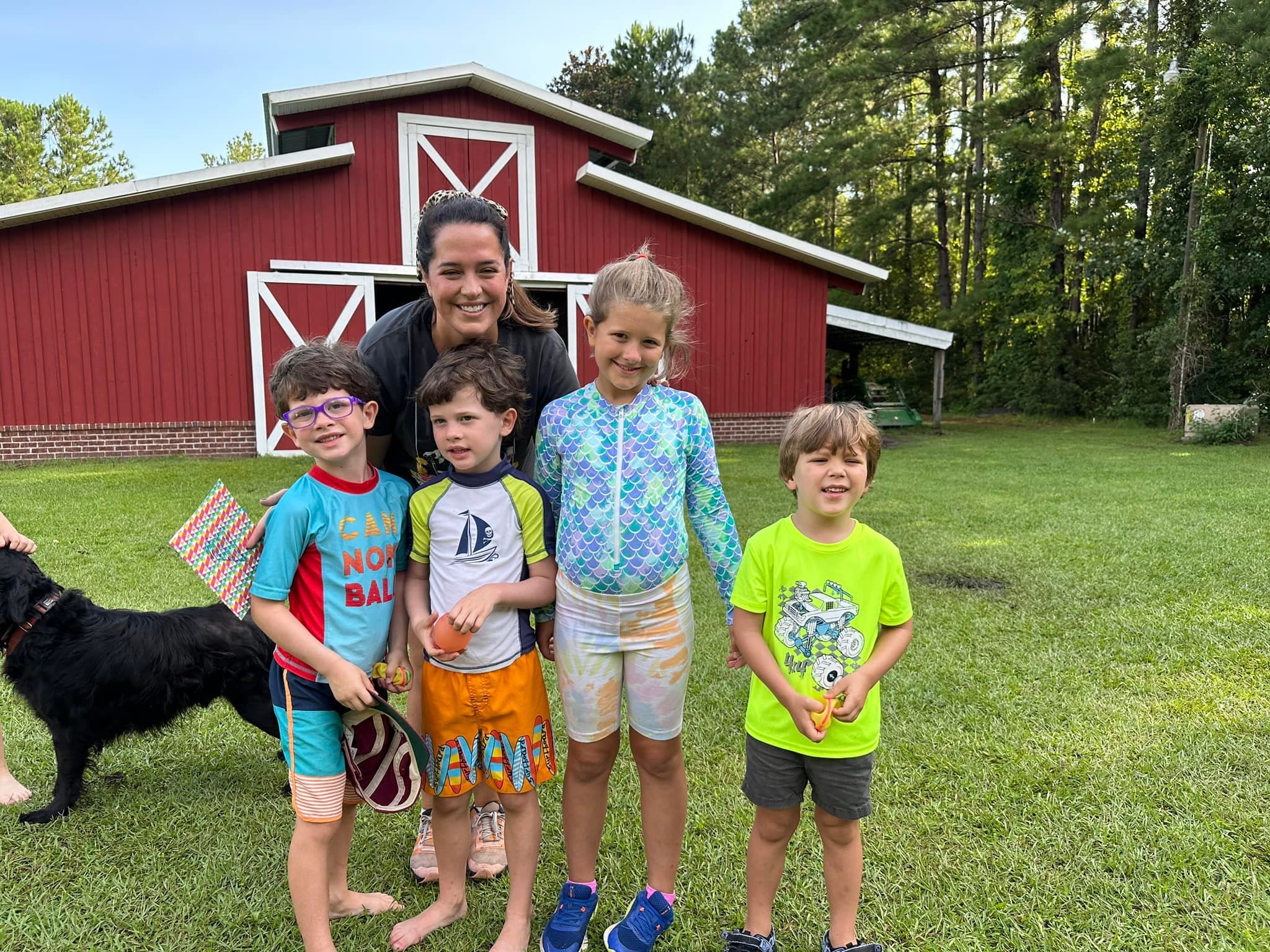 Katie with campers in front of The Red Barn